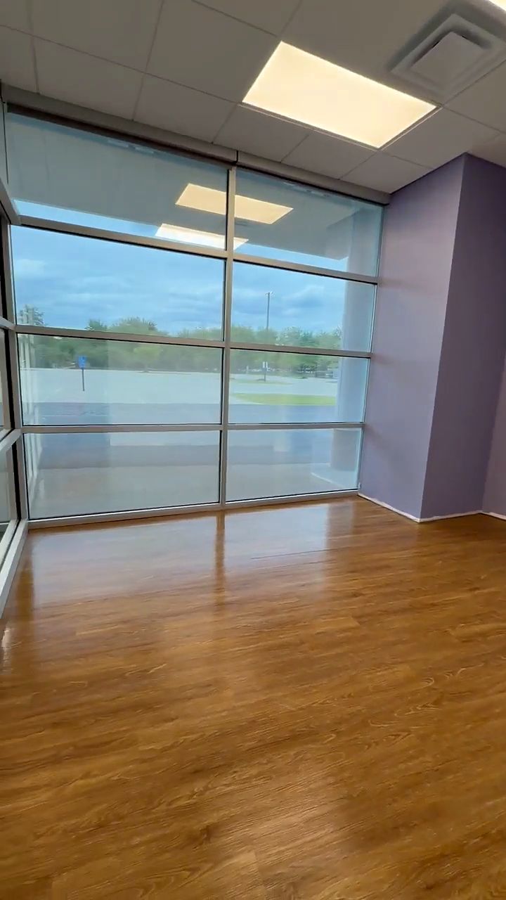Floor-to-ceiling windows and a high-gloss wood-look floor in a newly built medical office