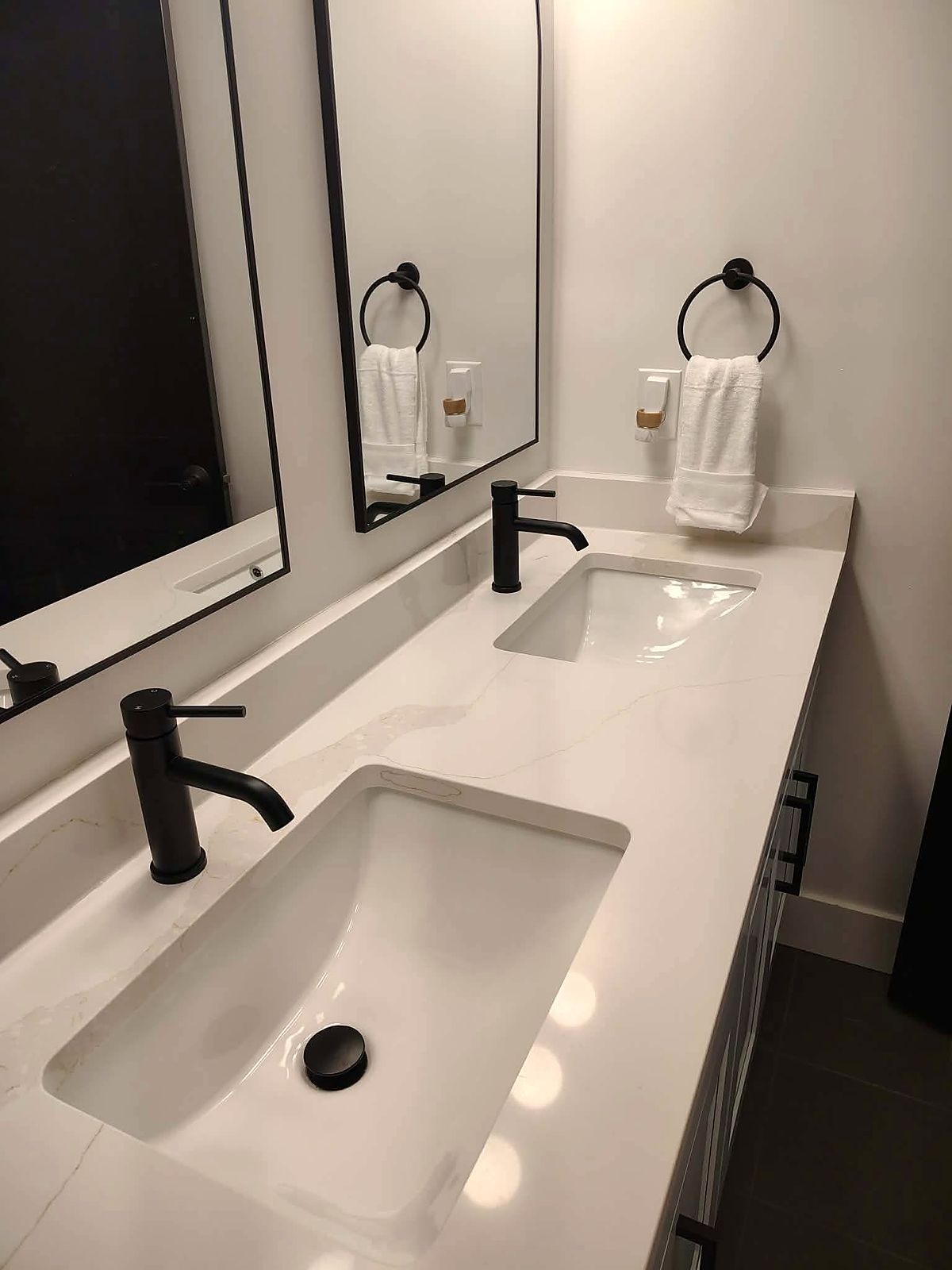 Spotless double vanity with a quartz counter, matte black faucets and fresh towels